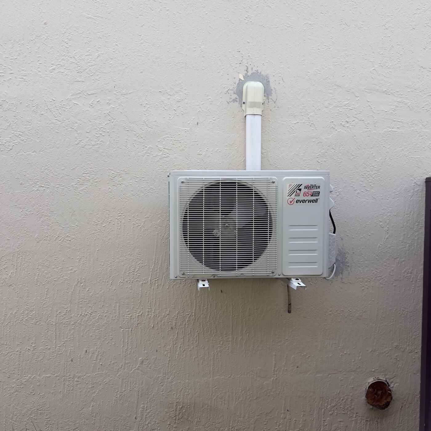 New inverter condenser unit installed on exterior wall